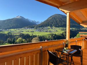 a table and chairs on a porch with a view at Alpenresort Panorama in Oberperfuss