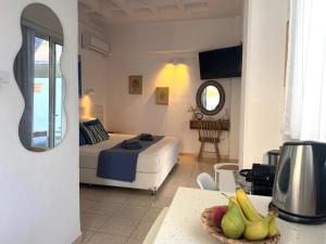 a bedroom with a bed and a table with a bowl of fruit at OLIA STUDIOS Olga studios in Faliraki