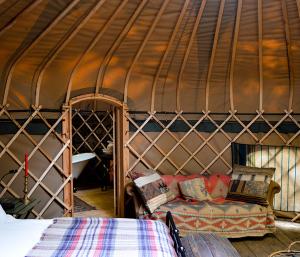 a room with a bed and a couch in a yurt at Adhurst Yurts in Sheet