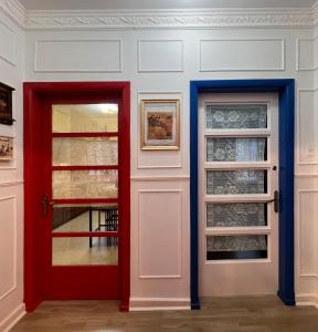a red door and two glass doors in a room at House Of Lith in Punta Arenas