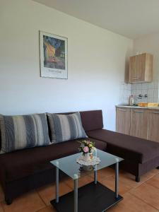 a living room with a brown couch and a table at Panoráma Vendégház in Sümeg