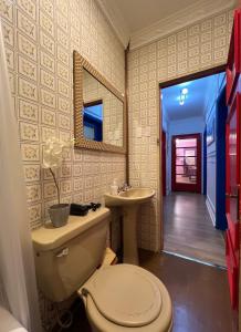 a bathroom with a toilet and a sink and a mirror at House Of Lith in Punta Arenas