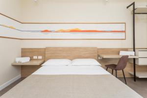 a bedroom with a large bed and a desk at Vulcanica By Dimorra in Pozzuoli