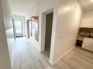 eine leere Küche mit weißen Wänden und Holzböden in der Unterkunft Villa Cologne - Apartments & Monteursquartiere in Meckenheim bei Köln in Meckenheim