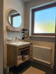 a bathroom with a sink and a mirror and a radiator at Alpenresort Panorama in Oberperfuss +51 photos