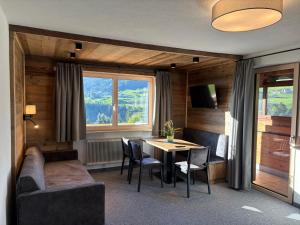 a living room with a table and chairs and a couch at Alpenresort Panorama in Oberperfuss