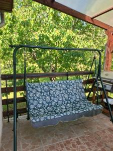a swing on a porch with a blue and white seat at Panoráma Vendégház in Sümeg +2 photos
