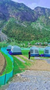 a man standing next to a group of tents at TIS Zipline Campingsite in Gurais