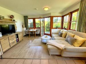 a living room with a couch and a tv at Oewern Diek App 03 in Wustrow