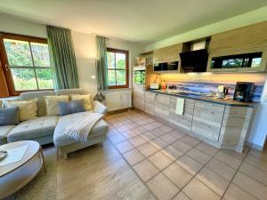 a living room with a couch and a kitchen at Oewern Diek App 03 in Wustrow