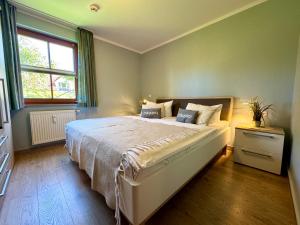 a bedroom with a large bed and a window at Oewern Diek App 03 in Wustrow