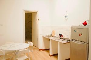 a kitchen with a white refrigerator and a table at CR BnB Rozzano 2 in Rozzano