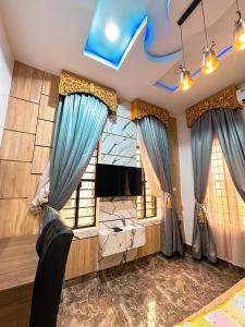 a living room with blue curtains and a television at The Movia Residences 1 in Enugu