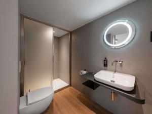 a bathroom with a toilet and a sink and a mirror at ibis Styles Ljubljana Centre in Ljubljana +53 photos