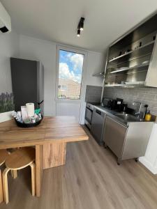 a kitchen with a wooden table and a sink at TheSnoozzze Boardinghouse Winsen - Monteur Apartments in Winsen