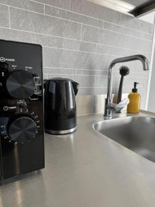 a toaster sitting on a kitchen counter next to a sink at TheSnoozzze Boardinghouse Winsen - Monteur Apartments in Winsen +17 photos