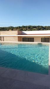 a large swimming pool in front of a building at La Pionera in Mejorada