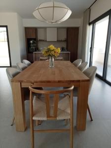 a dining room table with chairs and a vase of flowers on it at La Pionera in Mejorada
