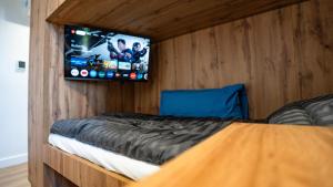 a bedroom with a bed with a tv on the wall at TheSnoozzze Boardinghouse Winsen - Monteur Apartments in Winsen