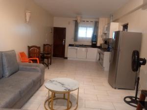 a living room with a couch and a kitchen at Heaven place -1 bedroom beachfront unit in Ukunda +4 photos