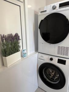 a washer and dryer in a white kitchen with a microwave at TheSnoozzze Boardinghouse Winsen - Monteur Apartments in Winsen