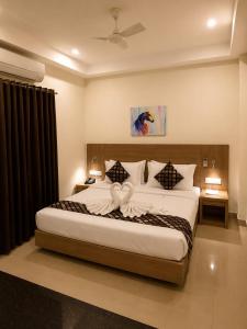 a bedroom with a large bed in a room at Hotel Sakthi in Kottayam +26 photos