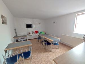 a classroom with tables and chairs in a room at Ubytovanie Erika in Vitanová