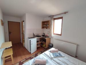 a small room with a bed and a kitchen at Ubytovanie Erika in Vitanová