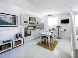 サン・ヴィート・ロ・カーポにあるLovely holiday home in San Vito lo Capo on the beachの白いキャビネットとテーブル付きのキッチンが備わります。