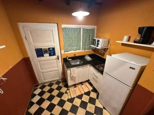 a small kitchen with a white refrigerator and a checkered floor at Taguato Recoleta in Asunción