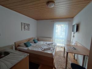 a small bedroom with a bed and a sink at Ubytovanie Erika in Vitanová +41 photos
