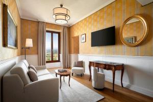 a living room with a tv and a couch and a table at Sina Brufani in Perugia