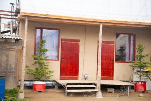 a house with red doors and a bench in front at Ethno Naryn Guest House in Naryn