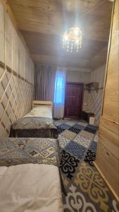 a room with two beds and a chandelier at Ethno Naryn Guest House in Naryn +3 photos