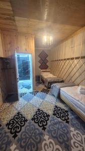 a room with two beds in a room with a pattern at Ethno Naryn Guest House in Naryn