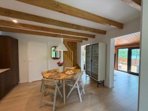 a kitchen and dining room with a table and chairs at Domek nad jeziorem z jacuzzi ROMANTICA in Wilamowo