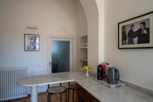 a kitchen with a counter with stools and a table at Il Giardino di Sofia in Arona