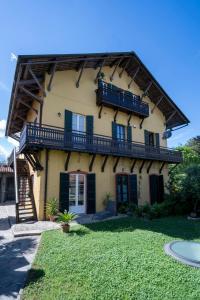 a house with a balcony and a yard at Il Giardino di Sofia in Arona