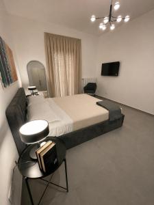 a bedroom with a large bed with two chairs and a television at Moon Apartments B in Soverato Marina
