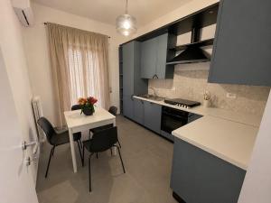 a kitchen with a table and chairs and a white counter top at Moon Apartments B in Soverato Marina