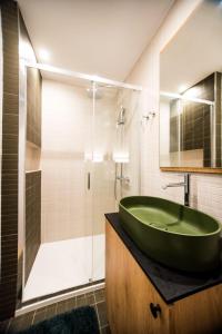 a bathroom with a green sink and a shower at Domek nad jeziorem z jacuzzi ROMANTICA in Wilamowo +41 photos