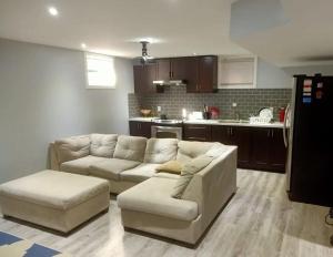 a living room with a couch and a kitchen at Cozy & Spacious 2-Bedroom Basement Suite in Brampton