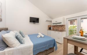 a bedroom with a bed and a kitchen with a table at Olive Dreams in Biograd na Moru