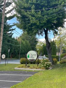 a sign on the side of a road next to a tree at Au p'tit cocon sur le lac in Magog-Orford