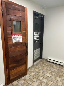 a wooden door with a sign on it next to a doorway at Au p'tit cocon sur le lac in Magog-Orford