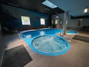 a large jacuzzi tub in the middle of a room at Au p'tit cocon sur le lac in Magog-Orford