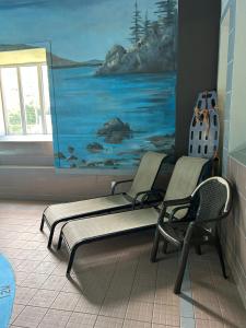 a room with two chairs and a painting on the wall at Au p'tit cocon sur le lac in Magog-Orford