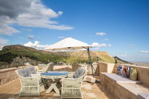 a patio with a table and chairs and an umbrella at Rocinante House in Mardin