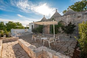 an outdoor patio with chairs and an umbrella at TRULOCO NUZZI - LUXURY DOMUS in Locorotondo