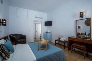 a bedroom with a bed and a desk and a mirror at CASA MIKELE by Sarikas - SEA SIDE SUITES and STUDIOS -adults only in Faliraki